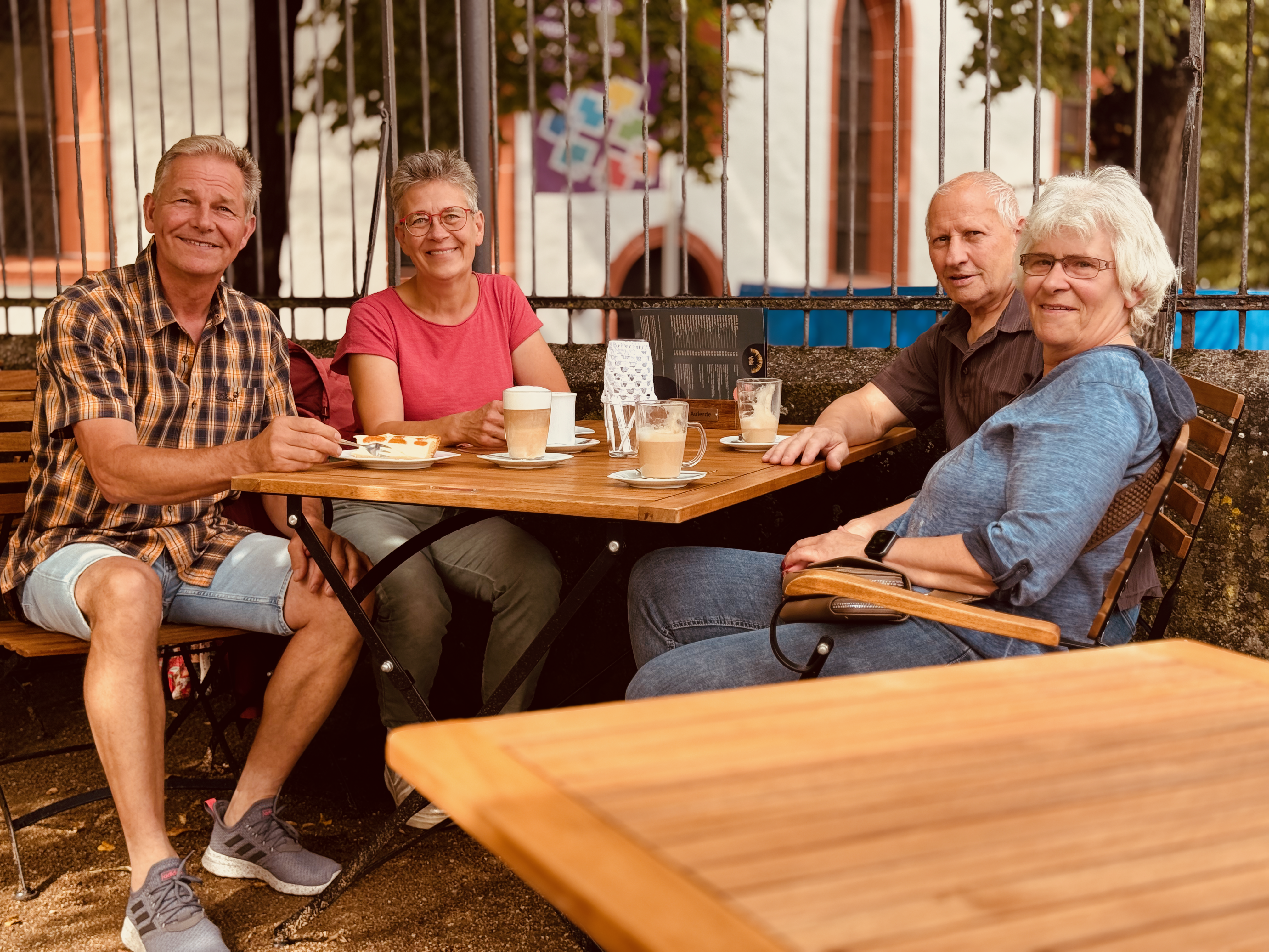 Vier Gäste am Bistrotisch, Kaffee und Kuchen